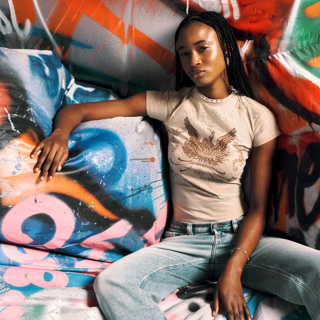 Magasinez les t-shirts pour femme avec un mannequin portant un t-shirt graphique de la collection automne-hiver 2025.
